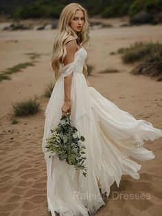 a woman in a white dress is walking on the beach with a bouquet of flowers