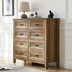 a wooden dresser sitting in a room next to a lamp