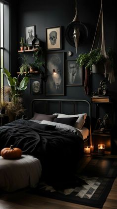 a bedroom with black walls and pictures on the wall above the bed is lit by candles