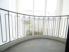 a curved balcony with white walls and metal railings