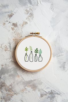 a cross stitch pattern with three vases and plants in them on a white surface