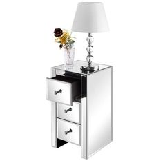 a mirrored night stand with two drawers and a flower vase on the bottom shelf, against a white background