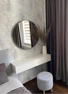 there is a mirror on the wall next to a white bench and stool in this room