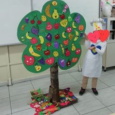 a person standing next to a tree with paper cutouts on it