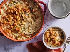 a bowl of macaroni and cheese next to two bowls of soup