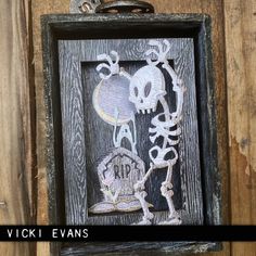 a wooden frame hanging on the wall with a skull and crossbones cut out of it