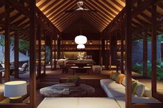 a living room filled with furniture under a wooden roof next to a dining table and chairs