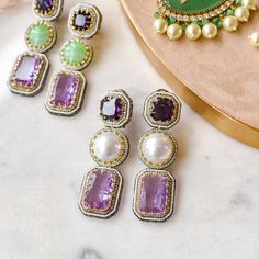 Look ravishing and take your love for long dangle earrings to another level! Gorgeous pair of earrings luxuriously studded with amethyst, pearl and CZ stones - perfect to wear them in your favorite fancy events to make all eyes rest on you. Approximate earrings length is 3.2". Designed over high-quality brass as base metal with silver and gold plating. Made by order. Kindly allow 4-6 weeks for the delivery of this item. For custom or urgent requests, please contact support@alacouture.com. *Please Note: We use faux stones and beads in all of our jewelry Unique Gift Cards, Long Dangle Earrings, Faux Stone, All Eyes, Green Stone, Cz Stone, All About Eyes, Base Metal, Free Giveaway