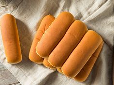 four hotdogs sitting on top of a piece of paper next to a knife