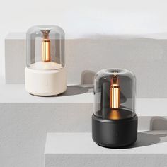 two lamps sitting next to each other on top of white and gray blocks with shadows