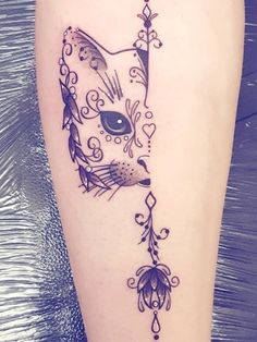 a tattoo on the leg of a woman with a cat's head and flowers