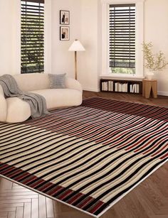 a living room filled with furniture and windows covered in shades of black and white stripes