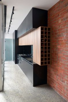 an empty kitchen with brick walls and black cabinets