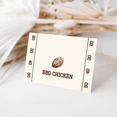 a close up of a ticket for a bbq chicken event with paper fans in the background