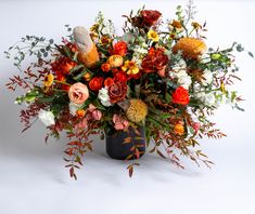 a vase filled with lots of different colored flowers