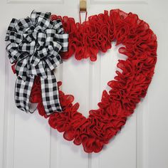 a heart shaped wreath hanging on the front door