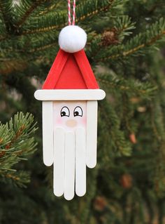 a christmas ornament hanging from a tree with santa's hat on it