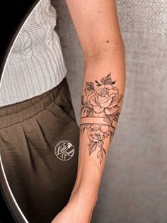 a woman with a rose tattoo on her arm