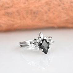 a black diamond ring sitting on top of a white surface