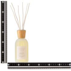 an image of a reed diffuser in front of a white background with black trim