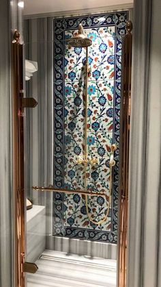 an ornate shower in a bathroom with blue and white tiles