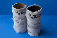 two pairs of white shoes with googly eyes and socks wrapped in paper on a blue background