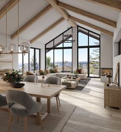 a large open living room and dining area with wood beams on the ceiling, glass windows overlooking mountains