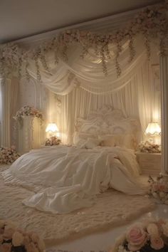 a white bed sitting under a canopy covered in flowers