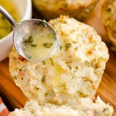 a spoon is being used to scoop broccoli out of some breaded muffins