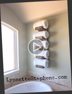 towels are hanging on the wall above a bathtub in a bathroom with a window