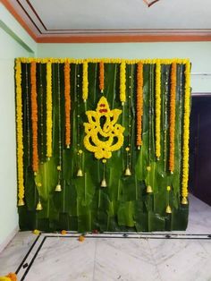 a wall decorated with yellow flowers and bells in the shape of a ganeshi