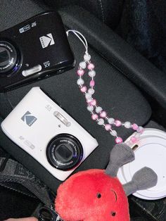 a camera, stuffed animal and other items are sitting in the back seat of a car