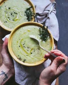 two bowls filled with soup sitting on top of a wooden table