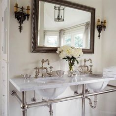 a bathroom with two sinks and a large mirror above the sink is shown in this image