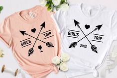 two t - shirts with arrows and hearts on them, one is pink and the other is white