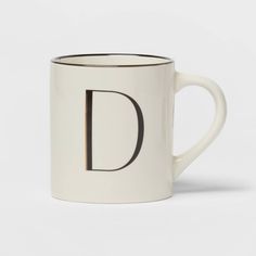 a white coffee mug with the letter d on it's side and black lettering