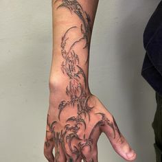 a person's hand with tattoos on it