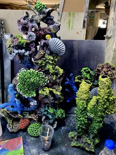 an assortment of corals and other marine life on a table next to a painting