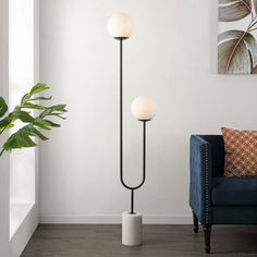 a living room with a blue couch and two floor lamps