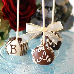 three chocolate covered candies are sitting on a cake plate with flowers in the background