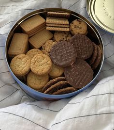 a metal bowl filled with cookies and crackers