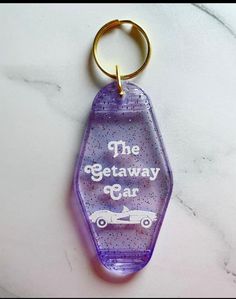 the getaway car keychain is purple and has an image of a car on it