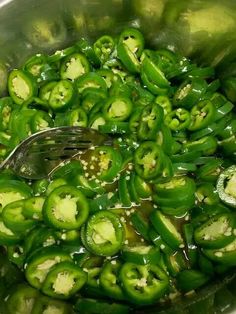 green peppers being cooked in a pot with a spoon