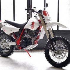 a white and red dirt bike parked in front of a building