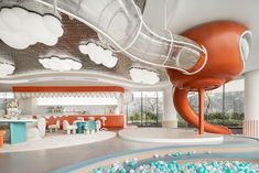 the inside of a children's playroom with an indoor slide in the background