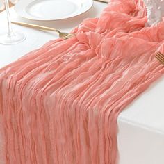 the table is set with pink linens and gold place settings