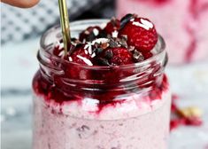 a person holding a strawberries and chocolate shake in a jar