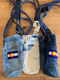 three pairs of jeans with the flag of colorado on them, hanging from a string