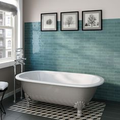 a white bath tub sitting next to two pictures on the wall