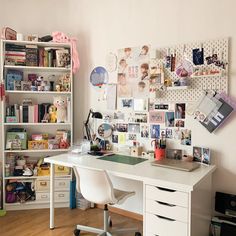 a white desk with lots of pictures on the wall